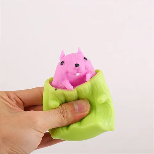 Pop-Up Squirrel Squeeze Toy Wooden Half-Tree Stump Pop-Up Miniature Stress & Anxiety Relief Desk Toy for Kids & Adults, Autism-Friendly Sensory Play buy online Beirut Lebanon A hand squeezes a bright green, wood-textured tree stump to reveal a cartoonish pink squirrel peeking out of the top. The background is solid white.