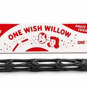 A product shot displaying a black, hollow lattice-structured stick resembling woven dark wood, lying below its vintage red-and-white packaging box. The box features bold red typography reading "ONE WISH WILLOW," "AMAZE YOUR FRIENDS," and "ONE WISH," accompanied by retro illustrations of a snapping stick with magical sparks and retro caricatures of a smiling boy and girl.